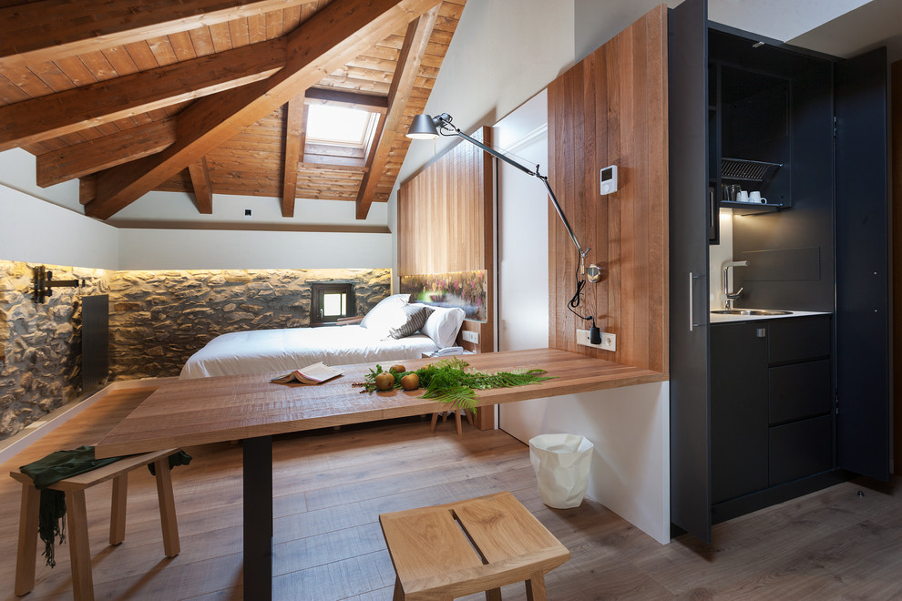Imagen de dormitorio rústico sin chimenea con paredes blancas, suelo de madera en tonos medios y suelo marrón