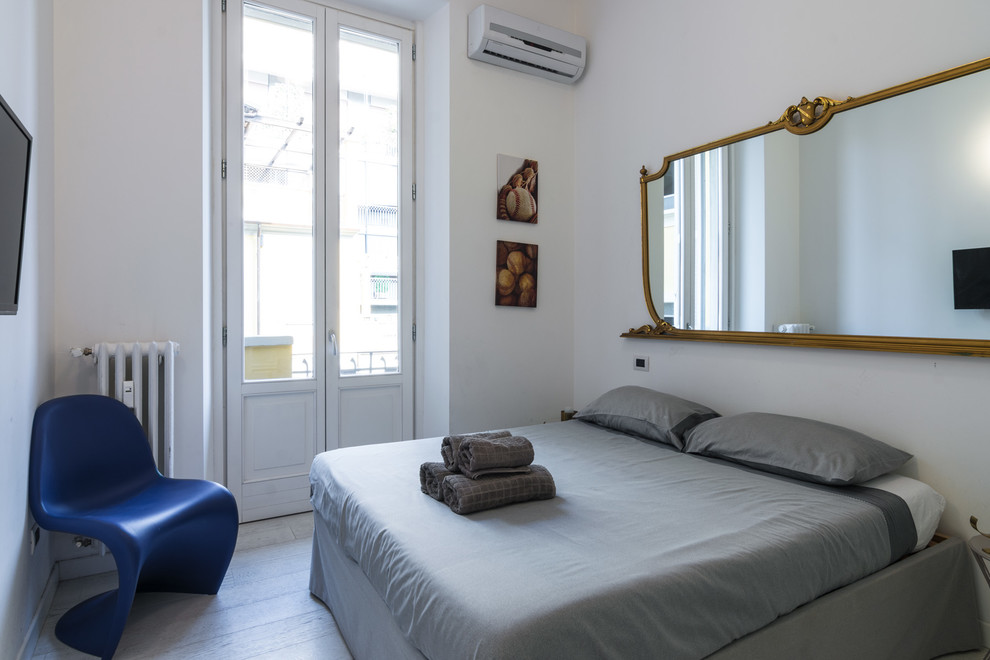 Foto di una camera degli ospiti minimalista con pareti bianche e parquet chiaro