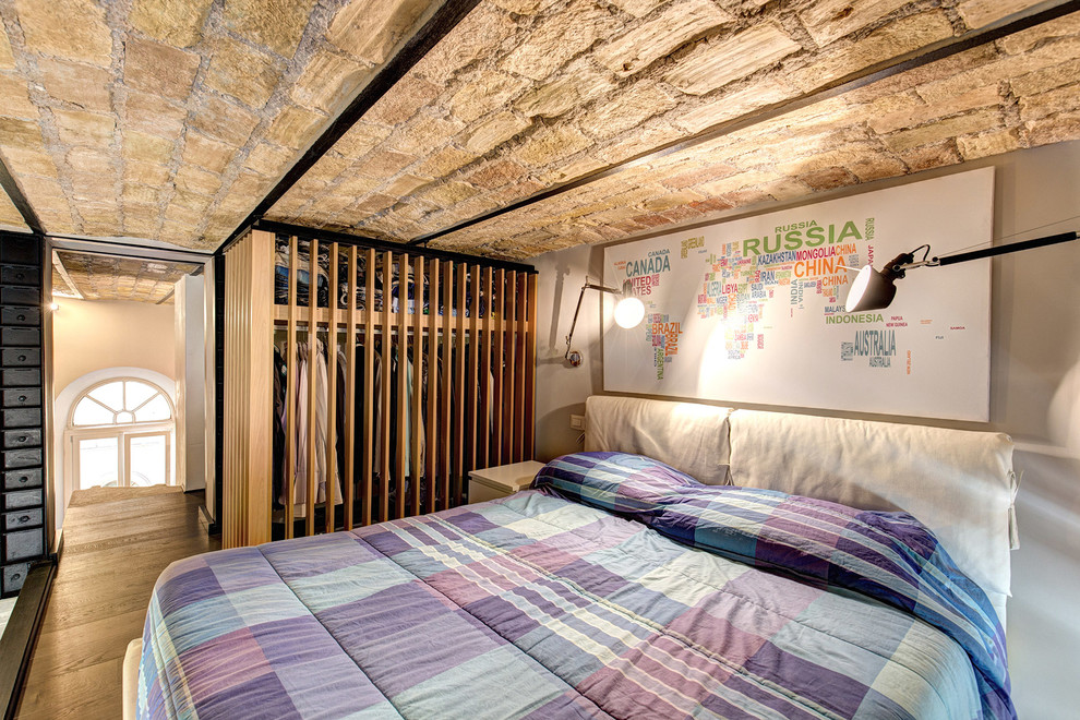 Immagine di una camera matrimoniale industriale di medie dimensioni con pareti beige, pavimento in legno massello medio e pavimento marrone