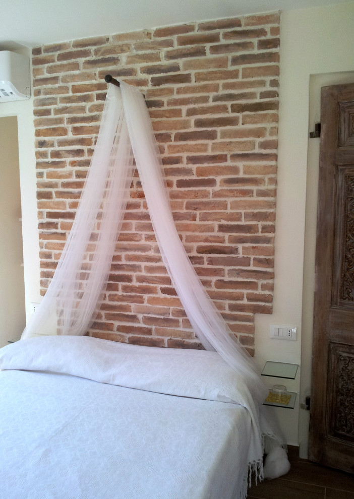 Esempio di una camera matrimoniale mediterranea con pareti bianche, pavimento in gres porcellanato e pavimento marrone