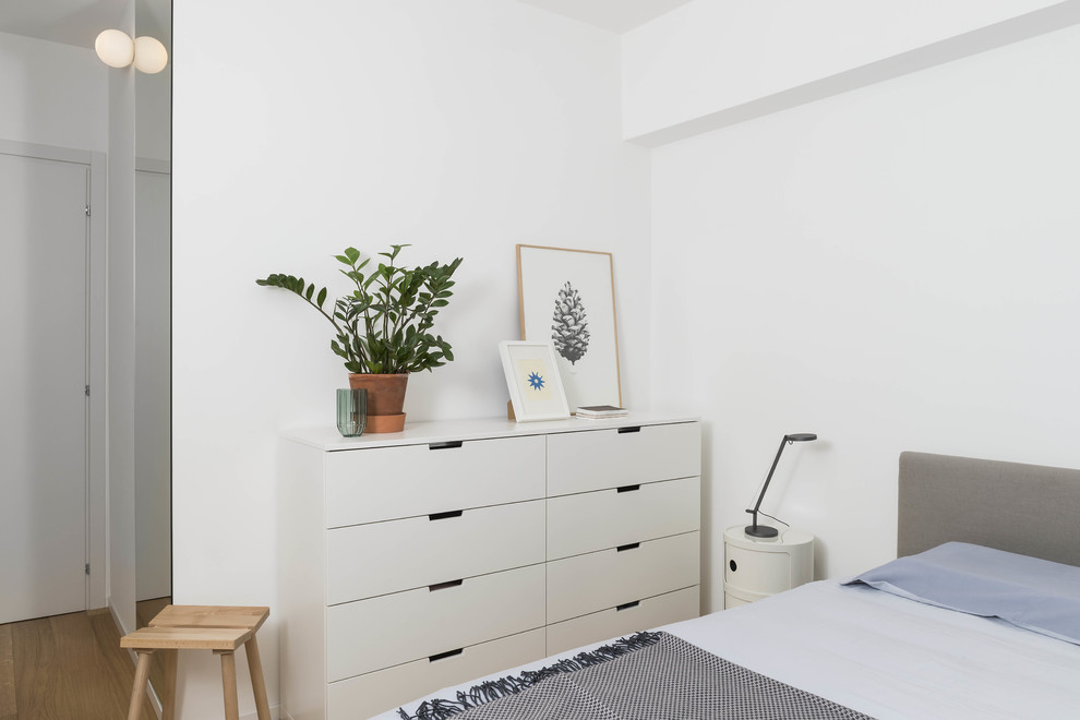 Exemple d'une chambre d'amis scandinave avec un mur blanc, un sol en bois brun et un sol beige.