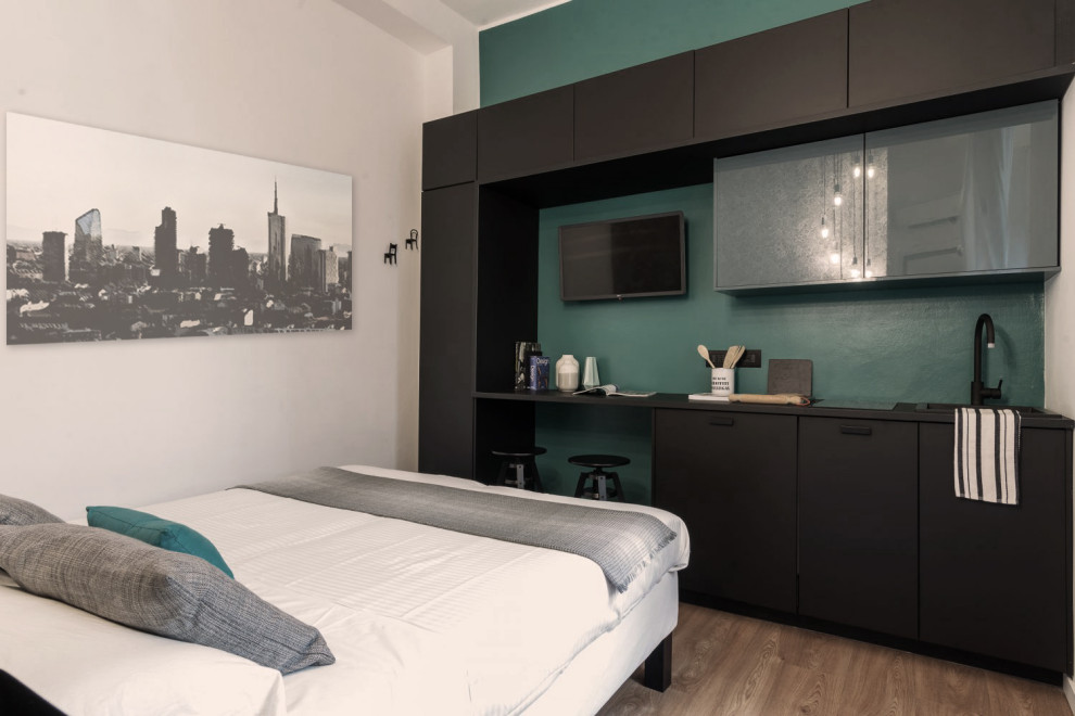 ミラノにある小さなコンテンポラリースタイルのおしゃれなロフト寝室 (緑の壁、クッションフロア、茶色い床) のインテリア