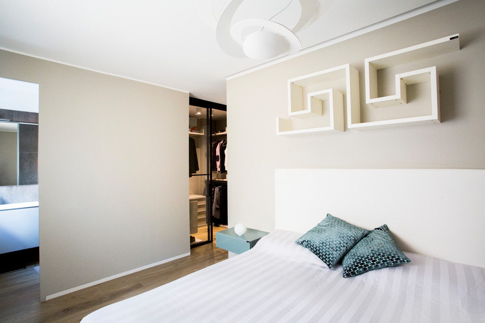 Immagine di una camera matrimoniale minimal di medie dimensioni con pareti beige e parquet chiaro