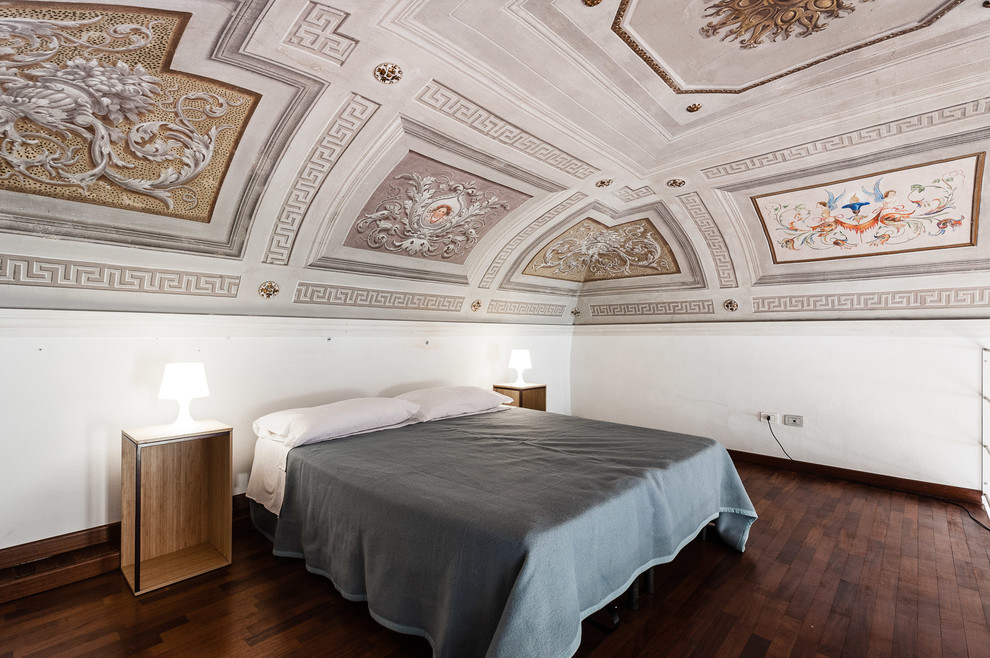 На фото: спальня в средиземноморском стиле с белыми стенами, темным паркетным полом и коричневым полом с