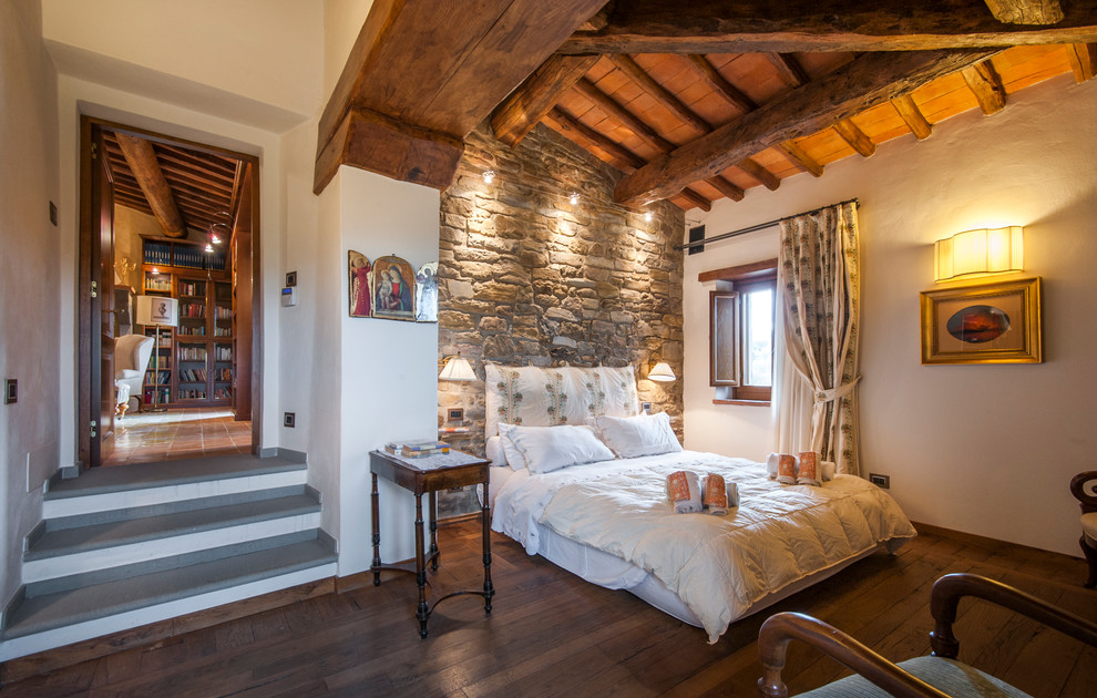 Imagen de habitación de invitados mediterránea con paredes blancas, suelo de madera oscura y suelo marrón
