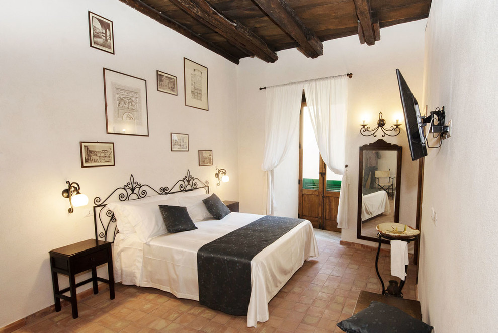 Imagen de dormitorio tradicional con suelo de baldosas de terracota