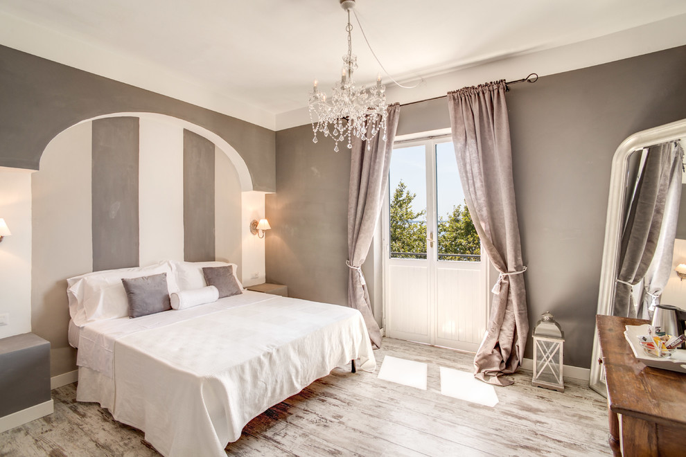 This is an example of a classic master bedroom in Rome with multi-coloured walls and painted wood flooring.