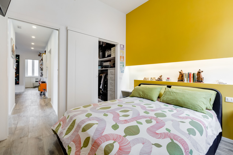 Foto di una camera matrimoniale design di medie dimensioni con pavimento in gres porcellanato e pareti gialle
