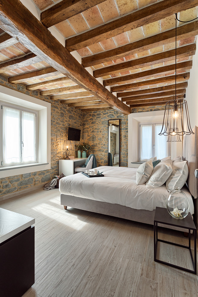 Exemple d'une chambre parentale méditerranéenne de taille moyenne avec parquet clair et un sol beige.