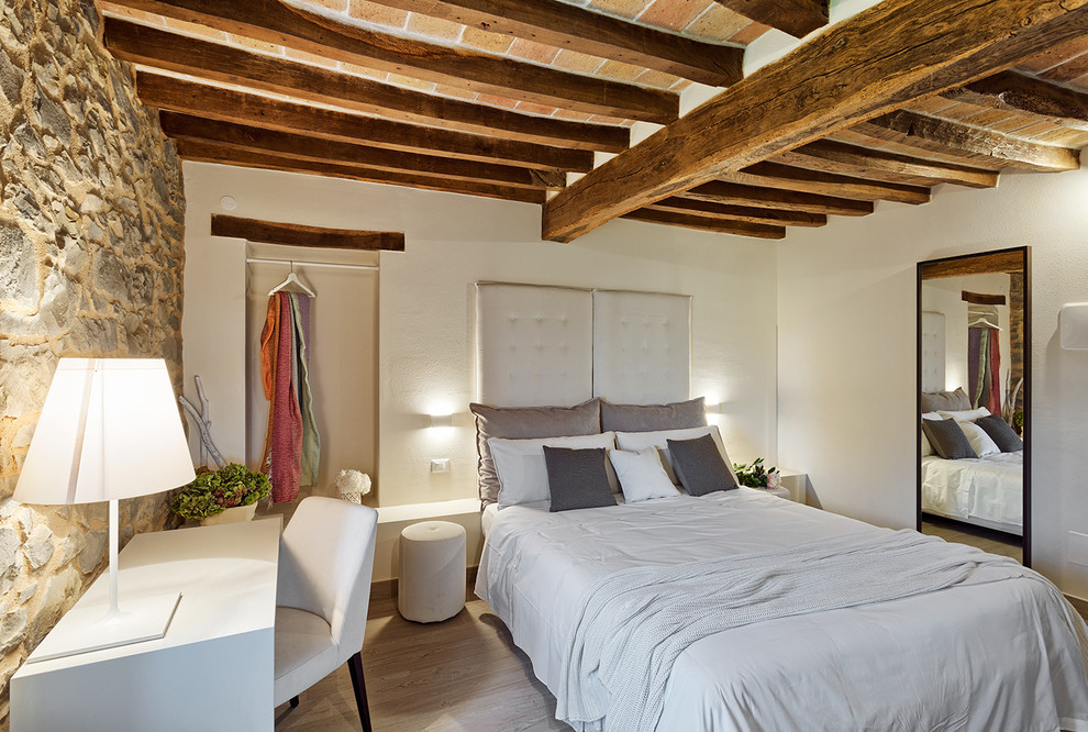 Mittelgroßes Modernes Hauptschlafzimmer mit weißer Wandfarbe, hellem Holzboden und weißem Boden in Bologna