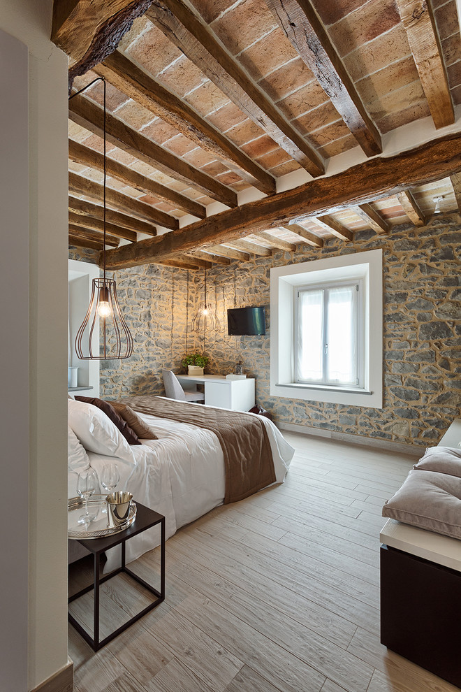 Imagen de dormitorio principal mediterráneo de tamaño medio con suelo de madera clara y suelo beige