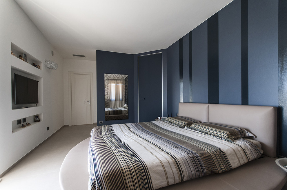 Idée de décoration pour une chambre parentale design avec un mur bleu.