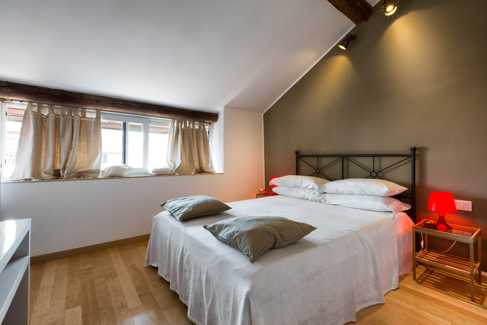 Modernes Hauptschlafzimmer mit weißer Wandfarbe und hellem Holzboden in Mailand