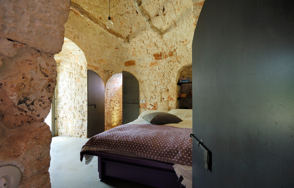 Idee per una camera matrimoniale mediterranea di medie dimensioni con pavimento in cemento, pavimento grigio e pareti beige