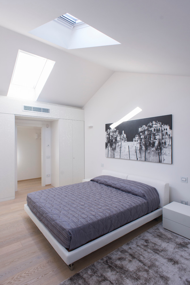 Foto de dormitorio principal actual con paredes blancas y suelo de madera clara