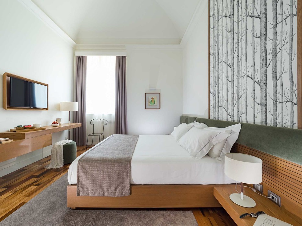 Ejemplo de dormitorio principal contemporáneo sin chimenea con suelo de madera oscura, paredes blancas y suelo marrón
