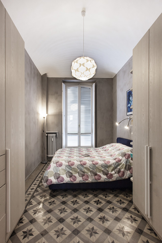 Kleines Modernes Hauptschlafzimmer mit grauer Wandfarbe, Terrakottaboden und buntem Boden in Turin