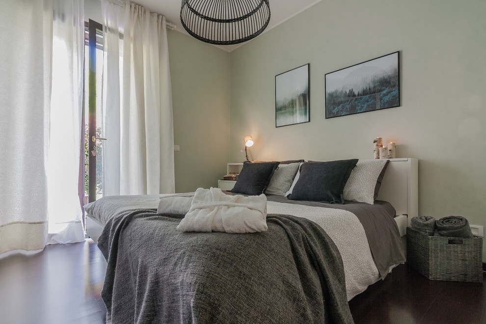 Expansive scandi master bedroom in Other with green walls, dark hardwood flooring and brown floors.