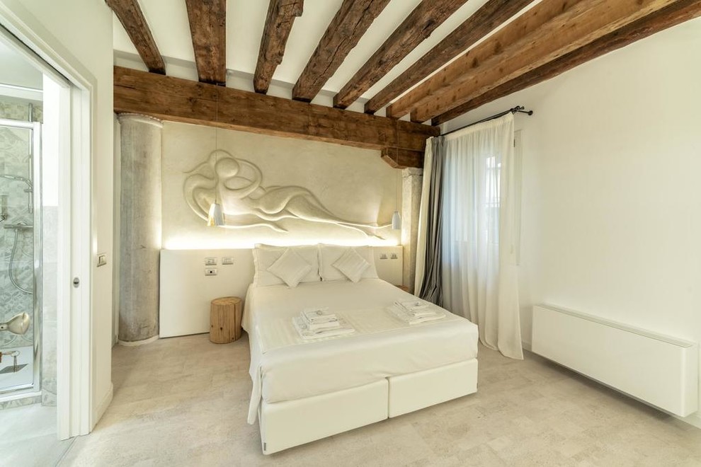 Imagen de dormitorio principal contemporáneo de tamaño medio con paredes blancas, suelo de corcho y suelo blanco
