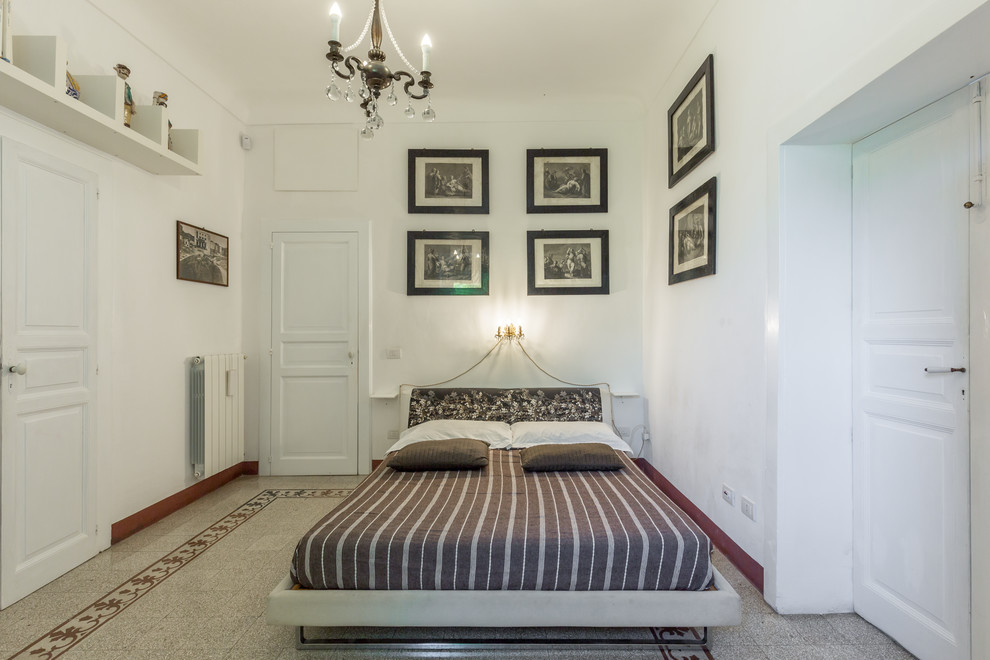 Foto di una camera da letto mediterranea con pareti bianche, nessun camino e pavimento multicolore