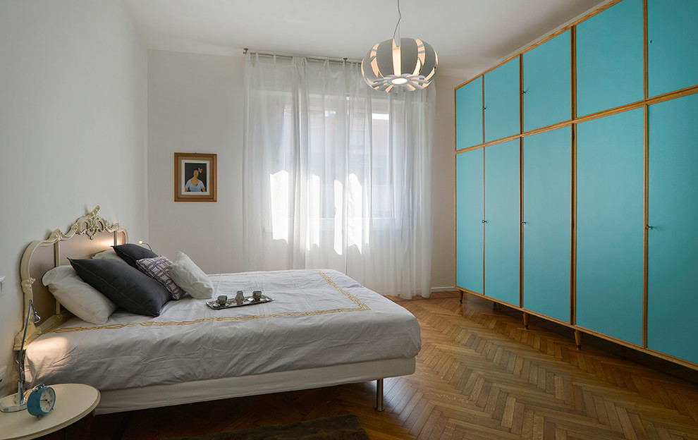 Cette photo montre une grande chambre parentale moderne avec un mur blanc, parquet clair et un sol marron.