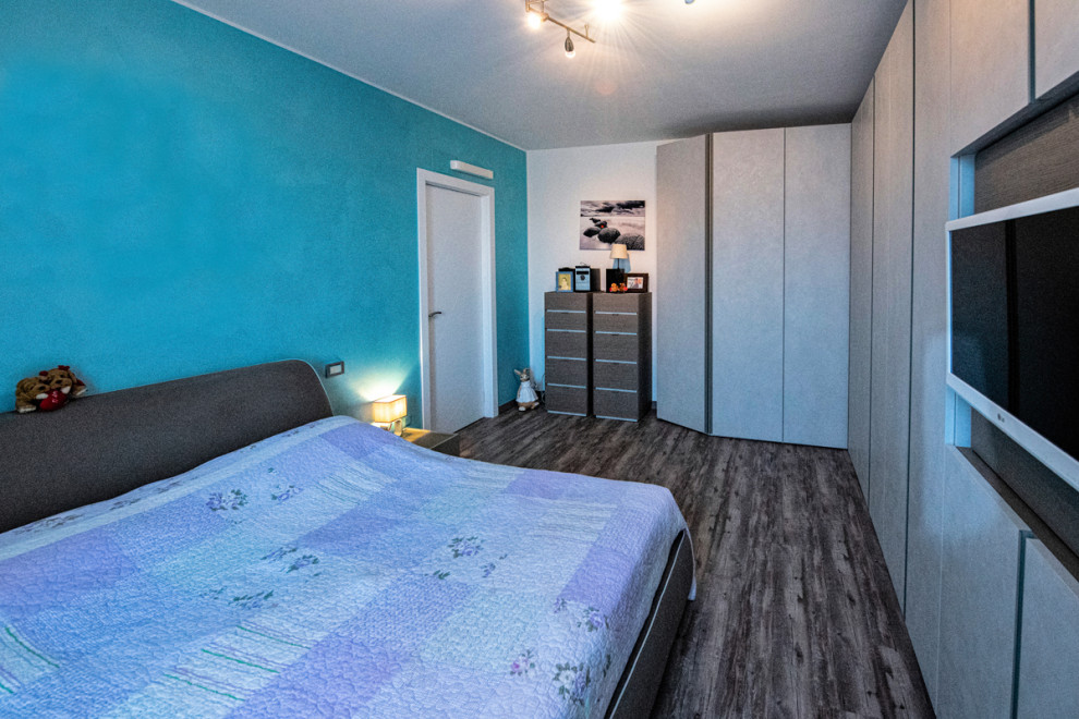 Foto de dormitorio principal actual de tamaño medio con paredes multicolor, suelo de baldosas de porcelana y suelo marrón