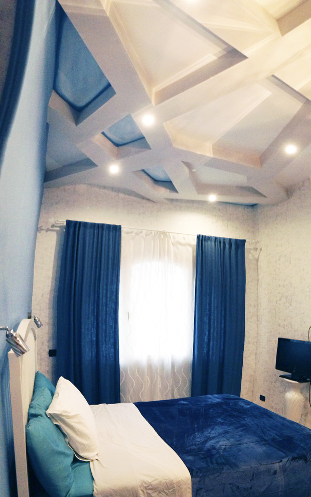 Esempio di una piccola camera matrimoniale contemporanea con pareti blu e parquet chiaro