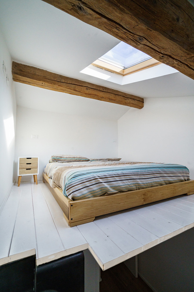 Immagine di una piccola camera da letto stile loft industriale con pareti bianche, parquet chiaro e pavimento bianco