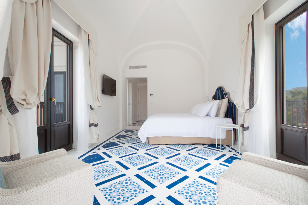 Immagine di una camera da letto mediterranea con pareti bianche e pavimento blu
