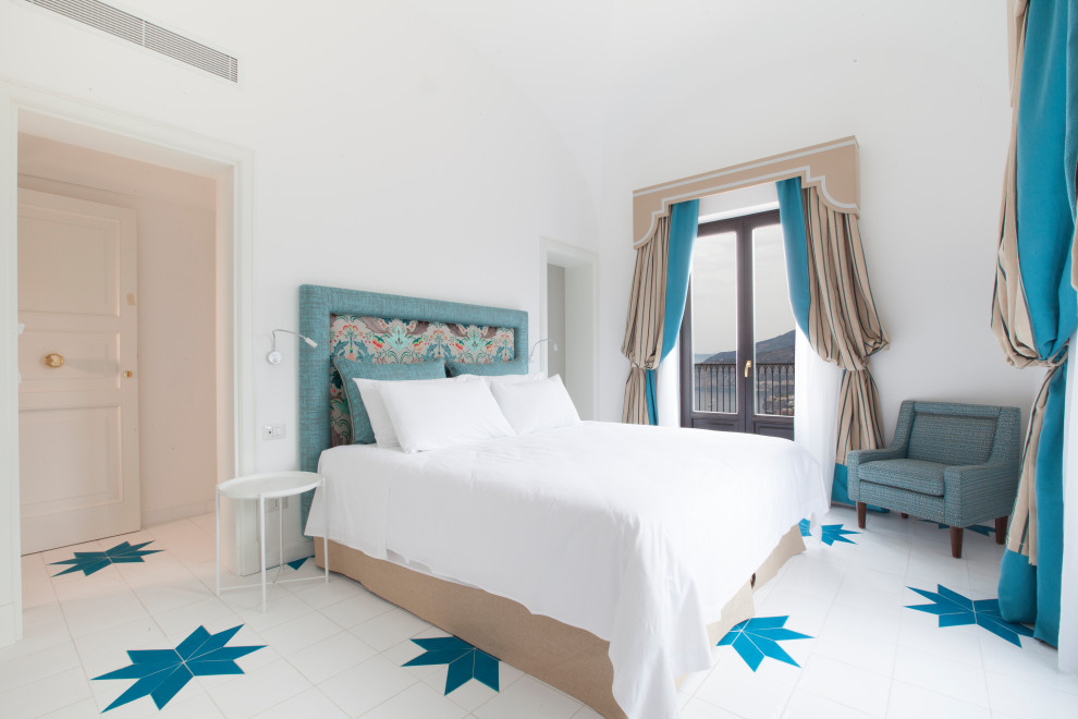 Foto di una camera da letto mediterranea con pareti bianche e pavimento multicolore