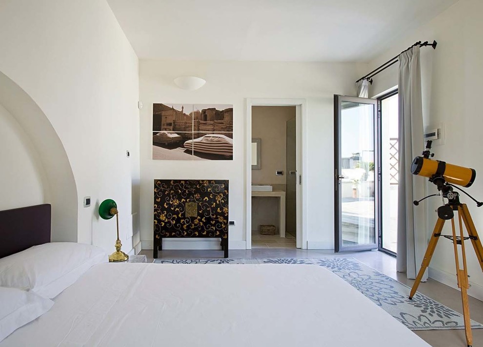Esempio di un'ampia camera degli ospiti mediterranea con pareti beige e pavimento in cemento