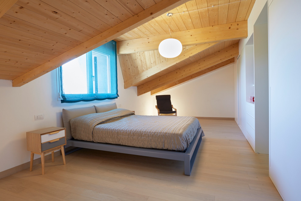 Photo of an expansive contemporary master bedroom in Bologna with white walls and light hardwood flooring.