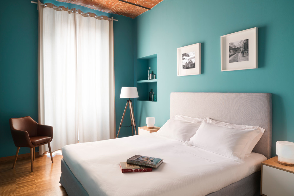 Exemple d'une chambre parentale tendance de taille moyenne avec un mur bleu, parquet foncé et un sol marron.