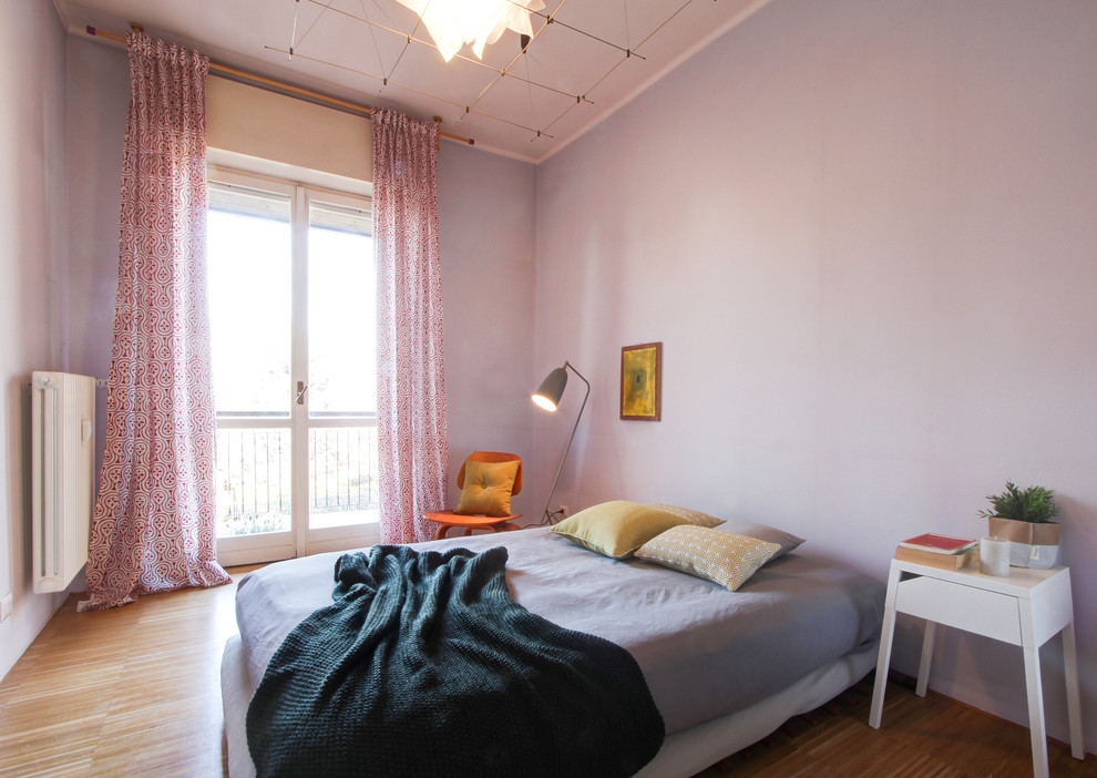 Idée de décoration pour une chambre parentale nordique avec un sol en bois brun, un mur violet et un sol marron.