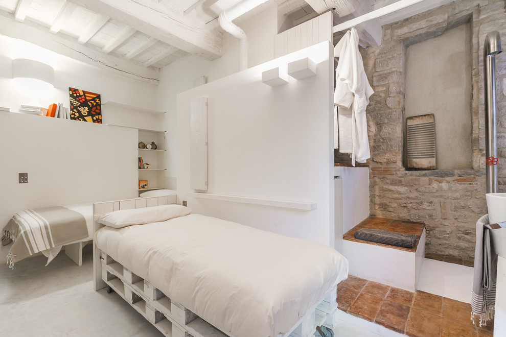 Immagine di una camera degli ospiti industriale con pareti bianche e pavimento in cemento