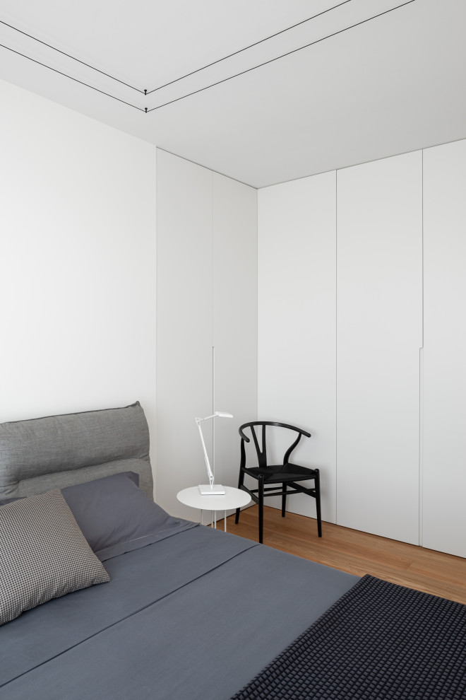 Mittelgroßes Modernes Hauptschlafzimmer ohne Kamin mit weißer Wandfarbe, hellem Holzboden und beigem Boden in Venedig