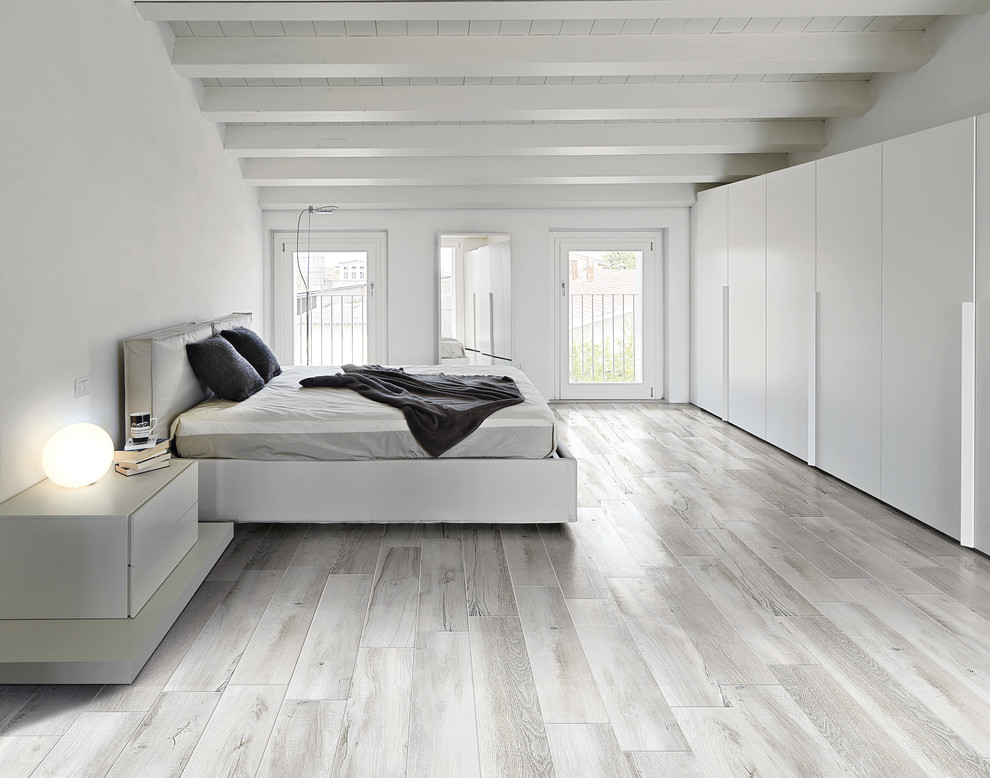 Ispirazione per un'ampia camera matrimoniale scandinava con pareti bianche, pavimento in gres porcellanato e pavimento grigio