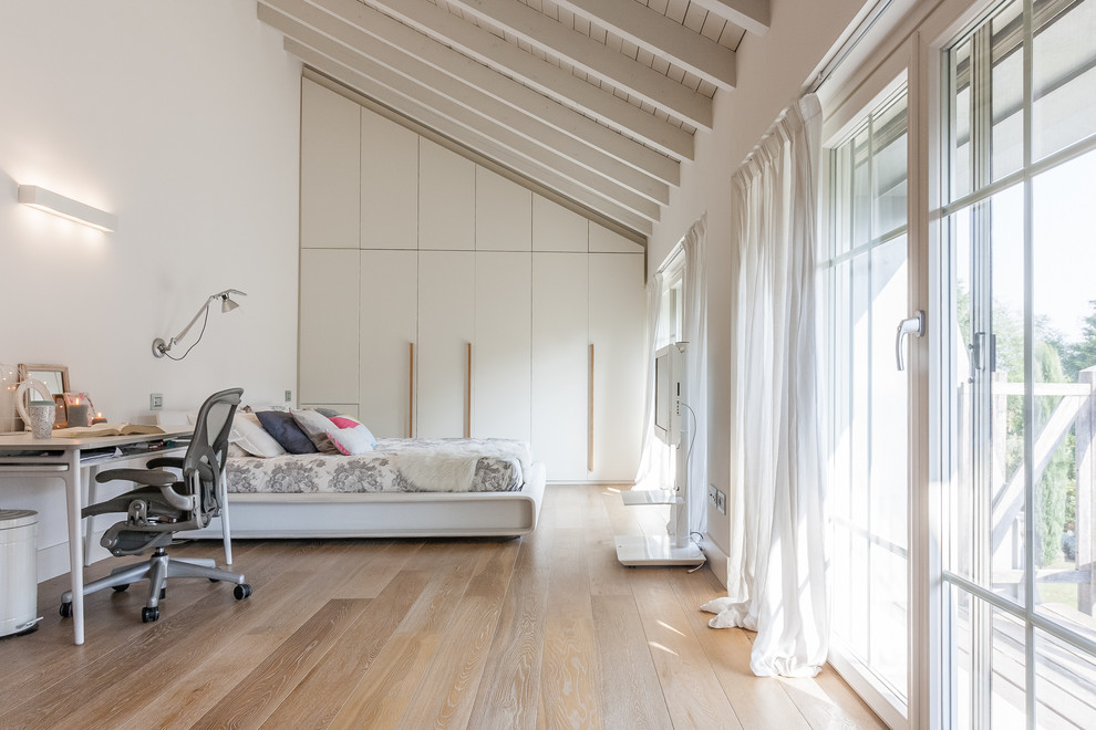 Immagine di un'ampia camera matrimoniale country con pareti bianche, parquet chiaro e pavimento beige