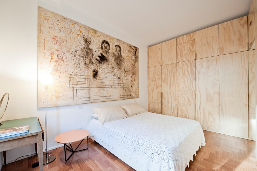 Esempio di una piccola camera matrimoniale scandinava con pareti bianche, pavimento in legno massello medio e pavimento beige