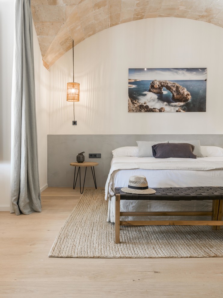 Immagine di una camera da letto mediterranea con pareti bianche, parquet chiaro e pavimento beige