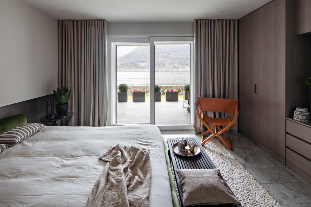 Immagine di una camera da letto minimal con pareti grigie, pavimento in marmo e pavimento grigio