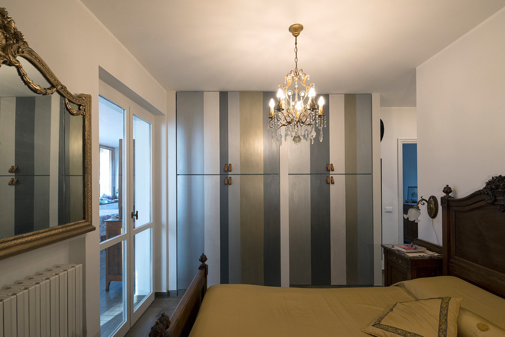 Ejemplo de dormitorio principal minimalista de tamaño medio con paredes blancas, suelo de baldosas de porcelana y suelo marrón