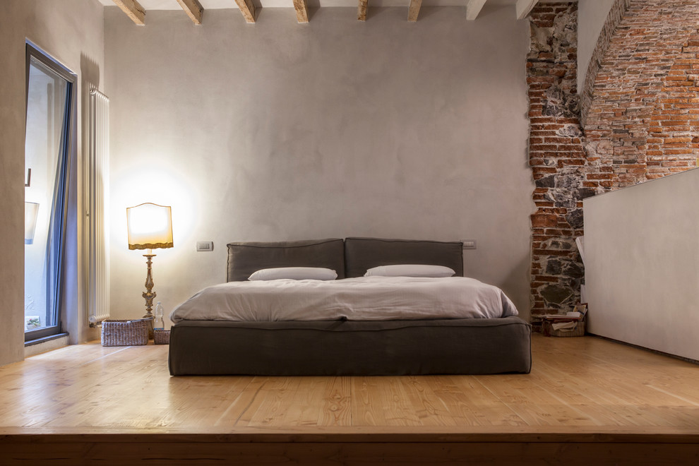 Mittelgroßes Mediterranes Hauptschlafzimmer mit weißer Wandfarbe und hellem Holzboden in Rom