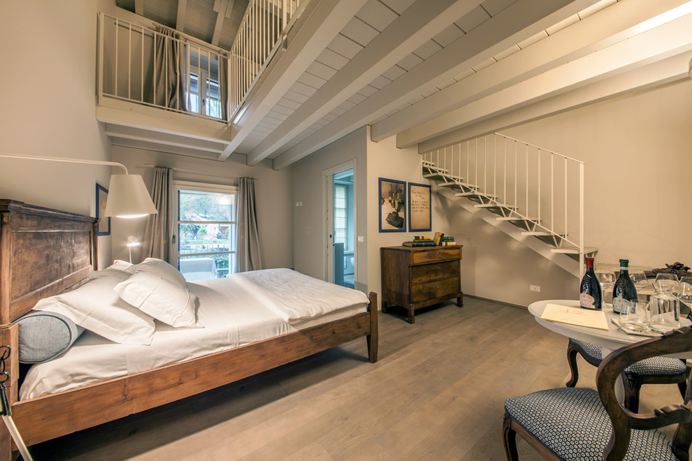 Cottage master light wood floor bedroom photo in Milan with beige walls