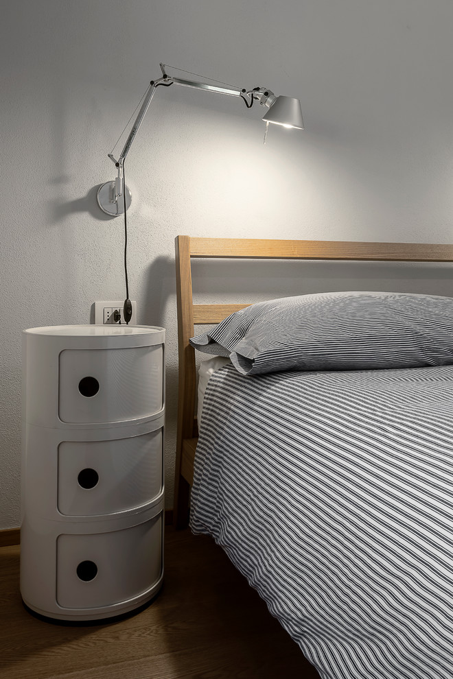 Example of a mid-sized danish master medium tone wood floor bedroom design in Milan with gray walls