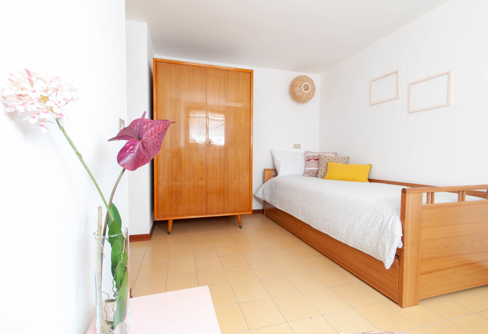Ejemplo de habitación de invitados actual pequeña con paredes blancas y suelo amarillo