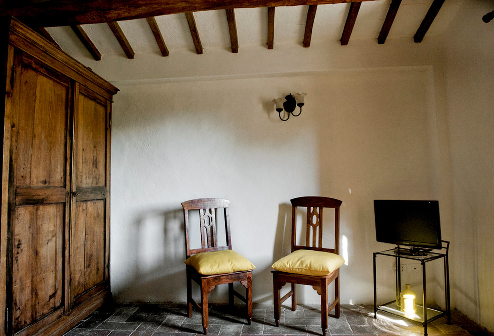 Mittelgroßes Landhausstil Gästezimmer mit weißer Wandfarbe, Terrakottaboden und braunem Boden in Rom