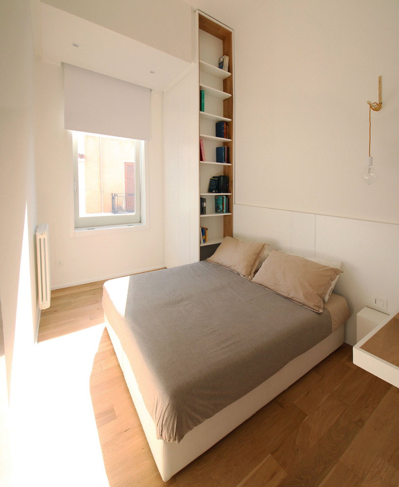 Ispirazione per una camera matrimoniale moderna di medie dimensioni con pareti bianche e pavimento in legno massello medio