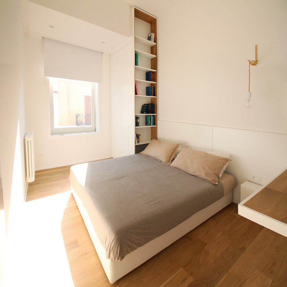 Foto di una camera degli ospiti contemporanea di medie dimensioni con pareti bianche e pavimento in legno massello medio