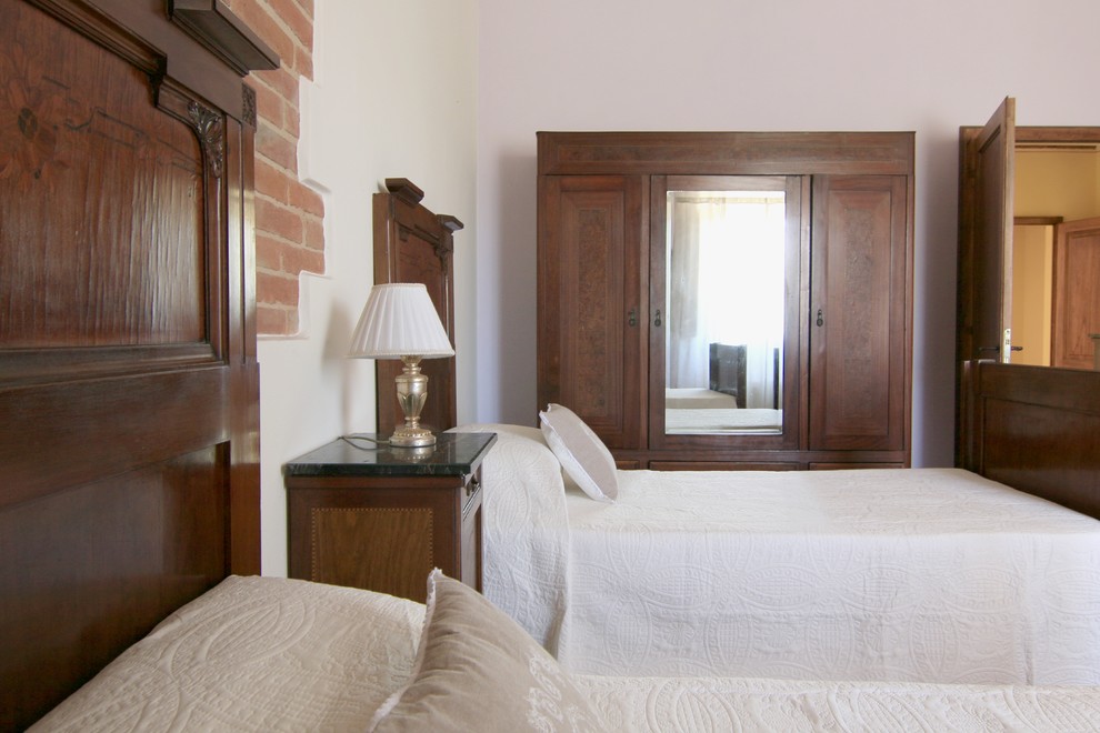 Idee per una camera degli ospiti country di medie dimensioni con pareti viola, pavimento in terracotta e pavimento marrone